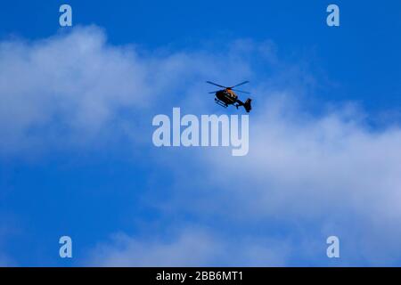 Polizeihubschrauber schwebt über London mit blauem Himmel und weißem Wolkenhintergrund, Strafverfolgungsbehörden, England, Großbritannien, Europa Stockfoto