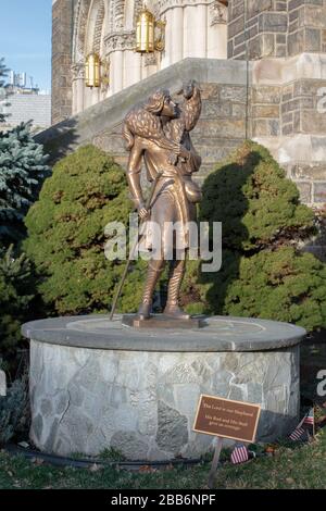 Eine Statue des guten Hirten mit Stab und Lamm oder Schaf über der Schulter vor einer katholischen Kirche gleichen Namens in Inwood, New York Stockfoto