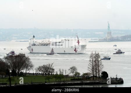 Mit einer Eskorte von Polizei und Löschbooten und Schleppbooten kam das Krankenhausschiff der US Navy, Comfort, gegen 10 Uhr morgens im Hafen von New York am 30. März 2020 an. Stockfoto