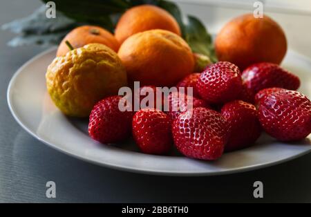 Teller mit frischen Erdbeeren, Orangen und Bergamot auf einem Teller Stockfoto