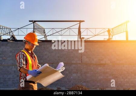 Bauarbeiter auf einer Baustelle mit Blick auf Pläne, Thailand Stockfoto