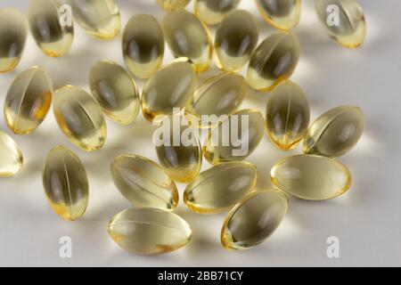 Gruppierung mehrerer Geltabulatoren von Fischöl-, Vitamin D- oder E-Supplementen auf weichem weißem Hintergrund Stockfoto