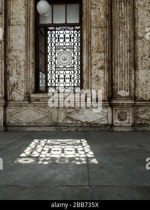 Ein typisch betutes Fenster einer Moschee in kairo und ein Schattenspiel Stockfoto