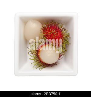 Rambutan in einer quadratischen Schüssel isoliert auf weißem Grund Stockfoto