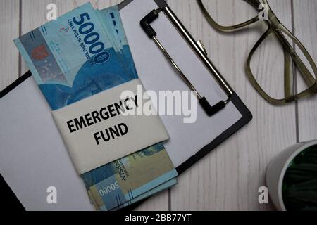 Notfallfondstext und indonesische Rupiah isoliert am Office Desk. Stockfoto