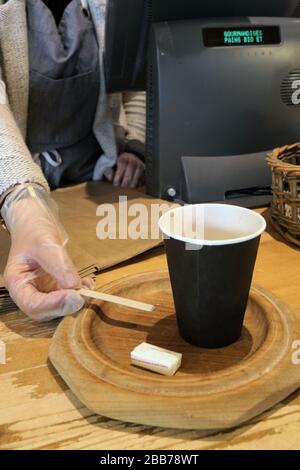 Boulangère vendant un Café dans un gobelet en carton avec des gants de Protection. Coronavirus. Covid-19.Saint-Gervais-les-Bains. Savoie. Frankreich Stockfoto