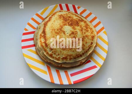 Goldene geröstete, geröstete Pfannkuchen werden auf einem Teller gestapelt. Stockfoto