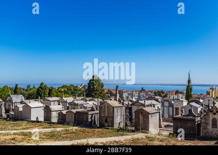 Mausoleen in Cemitéro do Alto de São João mit Stadtbild und Fluss Tejo im Hintergrund. Stockfoto