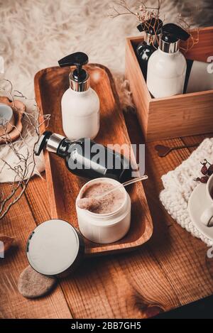 Kosmetikflaschen mit Kosmetik für die Körperpflege auf einem Holztisch. Whirlpool auf Holzgrund. Leeres Label für Branding Mock-up Stockfoto