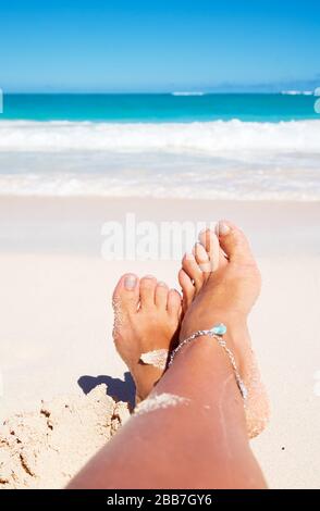 Schöne braune Beine am Strand fotografiert Stockfoto