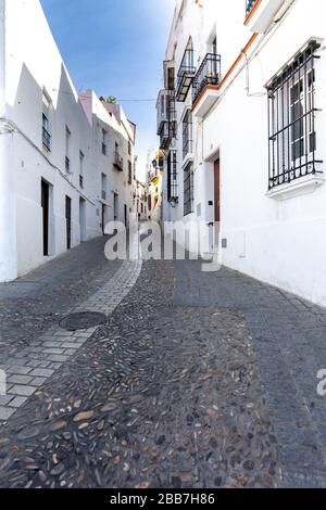 Kleine Straße in der Altstadt von Arcos de la Frontera, einer der berühmten weißen Städte Andalusiens, Spanien. Stockfoto