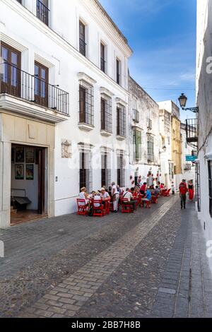 Tische eines Restaurants in der Straße in Arcos de la Frontera, einer der berühmten weißen Städte Andalusiens, Spanien. Stockfoto