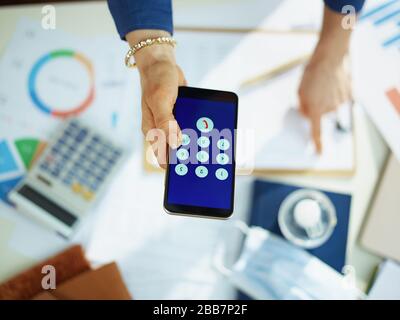 Obere Ansicht der Frau am Tisch mit Smartphone. Stockfoto