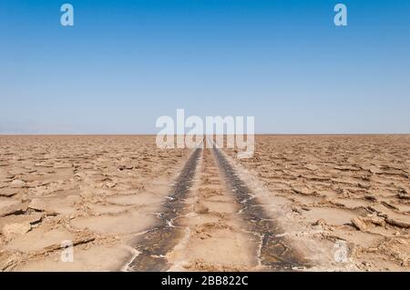 Afar Region, Danakil Depression, Nordäthiopien, Salt Desert, Road to Nowhere, Ricks in Road, Endless View, Noon, Clear Blue Sky Stockfoto