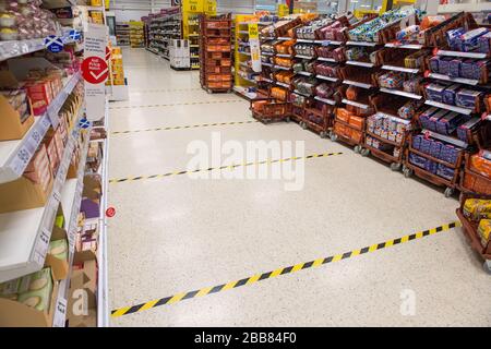Glasgow, Großbritannien. März 2020. Abgebildet: Ein Tesco-Laden in Glasgow zeigt Schilder und zwei Meter Markierungen rund um den Shop für soziale Distanzierung an, um die Ausbreitung von Coronavirus zu verhindern. Kredit: Colin Fisher/Alamy Live News Stockfoto