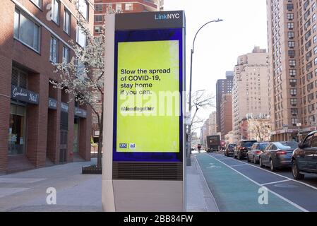 LinkNYC digitaler Kiosk auf dem Bürgersteig, der die Nachricht von Covid-19 (Coronavirus) anzeigt, um zu Hause zu bleiben. Stockfoto