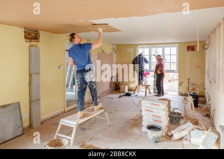 BUCKINGHAM, Großbritannien - 14. März 2016. Das Bauerteam arbeitet an einer Innenrenovierung mit einem Pflasterputz, der eine neue Decke abschiebelt Stockfoto