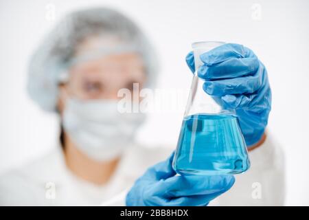 Wissenschaftler, die Schutzhandschuhe tragen, untersucht Flüssigkeit für den Coronavirus-Test Stockfoto
