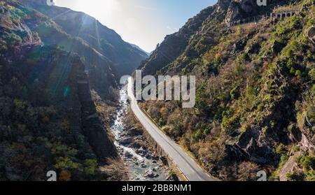 Der Gebirgsfluss entlang der Straße, ein Panorama-Dron-Blick auf eine malerische Autobahn durch die schöne Landschaft, die von Wolken und Nebel bedeckt ist, Brücke und Stockfoto