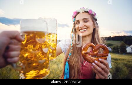 POV-Schuss von Paar in Bayern mit Bier toasten Stockfoto