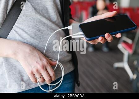 Weibliche Hände mit Smartphone und Powerbank Stockfoto