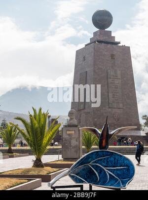 Quito, Ecuador - 30. Juli 2018: Eine schöne bunte hummingbird Skulptur mit dem Denkmal des Äquators im Hintergrund. Stockfoto