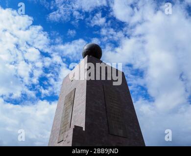 QUITO, ECUADOR - 30. JULI 2018: Ein niedriger Blickwinkel auf die Süd- und Westseite des Monuments to the Equator gegen einen wolkigen blauen Himmel. Stockfoto