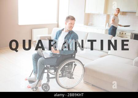 Attraktive junge Kursteilnehmer mit Integration und Behinderung. Das Sitzen auf einem Stuhl und zurück zu schauen. Junge Frau Kochen am Herd. Blick einander an. Coup Stockfoto