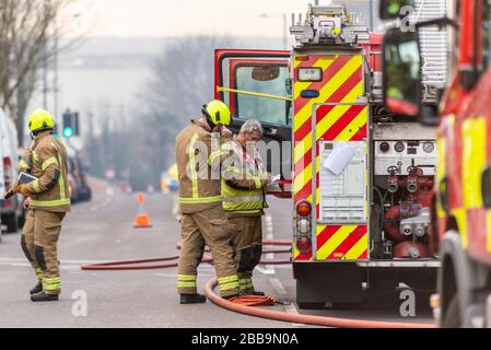 Feuerwehr, die sich während der COVID-19-Sperre mit einem Brand neben Sainsbury's Supermarkt in Westcliff on Sea, Essex, Großbritannien auseinandersetzt. Der Offizier, der Notizen gemacht hat Stockfoto