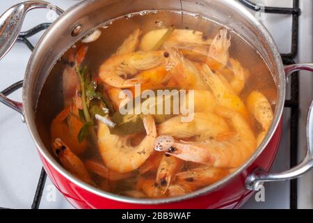 Pfanne mit King-Garnelen, die mit Gewürzen auf dem Herd kochen, Nahaufnahme Stockfoto