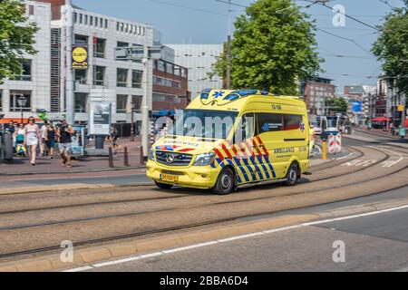 Amsterdam, Holland, Niederlande, August 2018, Rettungswagen, der durch das Zentrum von Amsterdam in der Nähe der Stopera über die Brücke am Fluss Amstel Yell beschleunigt Stockfoto