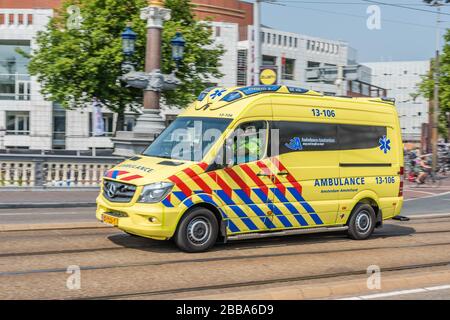 Amsterdam, Holland, Niederlande, August 2018, Rettungswagen, der durch das Zentrum von Amsterdam in der Nähe der Stopera über die Brücke am Fluss Amstel Yell beschleunigt Stockfoto