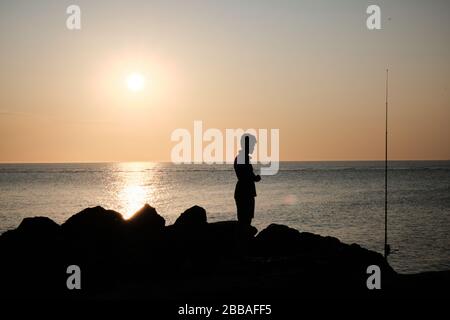 Blick auf einen Fischer-Schatten auf den Felsen der Küste von Punta Ballena an der Bucht von Solanas, atlantik, Maldonado, Uruguay Stockfoto