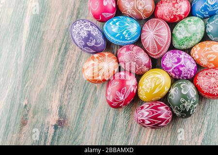 Verschiedene farbenfrohe, handgefertigte, zerkratzte ostereier auf Holztisch Stockfoto
