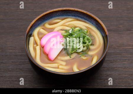 Japanische Curry-Eudon-Nudeln in einer Keramikschale auf dem Tisch Stockfoto