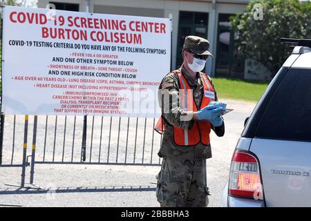 Pvt. Pat Dawsonhassell, ein 20-jähriger Einwohner von Lake Charles mit Headquarters and Headquarters Company, 3rd Battalion, 156th Infantry Regiment, 256th Infantry Brigade Combat Team, untersucht Patienten auf einem mobilen Testgelände von COVID 19 im Burton Coliseum in Lake Charles, Louisiana, 26. März 2020. (USA Foto der Nationalgarde der Luftwaffe von Meister Sgt. Toby Valadie) Stockfoto