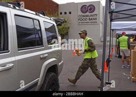 Mitglieder des Dienstes der Nationalgarde von Arizona liefern Essen an die Bewohner des Pima County am 26. März 2020 bei der Community Food Bank of Southern Arizona in Tucson, Ariz. Diese Woche wird die Garde mehr als 700 Arizona-Citizen-Soldaten und Luftfahrer aktivieren, um Lebensmittelgeschäfte zu unterstützen. Lebensmittelbanken und andere kommunale Bedürfnisse während dieses Ausnahmezustands. (USA Air National Guard Foto von Staff Sergeant Kelly Greenwell) Stockfoto