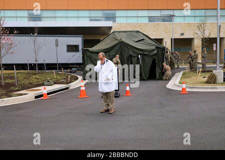 Mitglieder der 224th Medical Company Area Support der Maryland Army National Guard mit Hauptsitz in Olney, Maryland, richten am 19. März 2020 ein mittleres Zelt außerhalb der Notaufnahme im Adventist Healthcare White Oak Medical Center in Silver Spring, Maryland, ein. Das Zelt und bis zu 30 Sanitätssoldaten sind vorhanden, um die Mitarbeiter des Krankenhauses in Notfällen zu unterstützen. Stockfoto