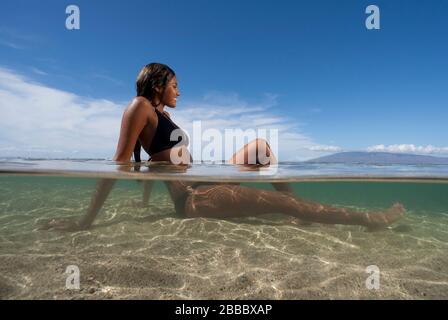 Attraktive Frau entspannt sich im Wasser in Lahaina, Maui, Hawaii. Stockfoto