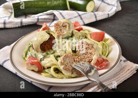Zucchini Pasta mit Basil Pesto Alfredo Soße und Fleischbällchen Stockfoto
