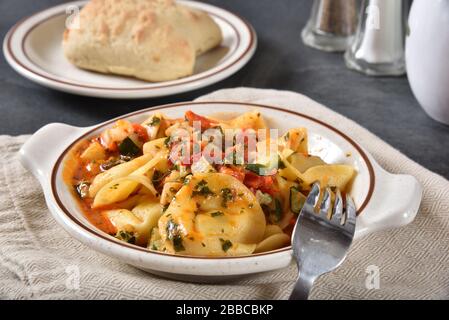 Tortellini gefüllt mit Ricotta-Käse und Spinat in roter Pesto-Sauce Stockfoto