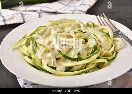 Cremige Basil Pesto alfredo Soße auf spiraliertem Zucchini Squash Stockfoto