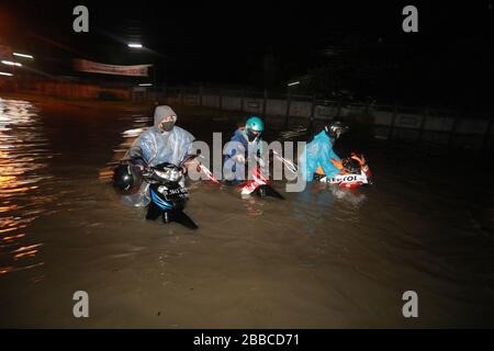 Bandung Regency, Indonesien. März 2020. Ein Motorradfahrer überquert die Straße bei einem Hochwasser in Bandung regency, West Java, Indonesien, 30. März 2020. Überschwemmungen aufgrund starker Regenfälle. (Foto von Agvi Firdaus/INA Photo Agency/Sipa USA) Credit: SIPA USA/Alamy Live News Stockfoto