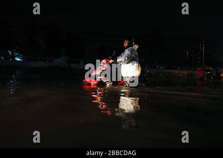 Bandung Regency, Indonesien. März 2020. Ein Motorradfahrer überquert die Straße bei einem Hochwasser in Bandung regency, West Java, Indonesien, 30. März 2020. Überschwemmungen aufgrund starker Regenfälle. (Foto von Agvi Firdaus/INA Photo Agency/Sipa USA) Credit: SIPA USA/Alamy Live News Stockfoto