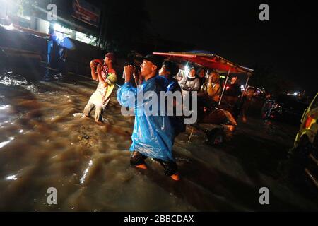 Bandung Regency, Indonesien. März 2020. Anwohner passieren die Straße bei einem Hochwasser in Bandung Regency, West Java, Indonesien, 30. März 2020. Überschwemmungen aufgrund der starken Regenintensität. (Foto von Agvi Firdaus/INA Photo Agency/Sipa USA) Credit: SIPA USA/Alamy Live News Stockfoto