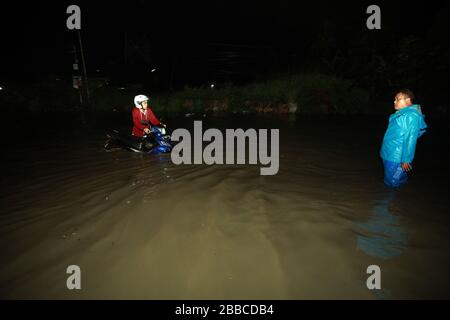 Bandung Regency, Indonesien. März 2020. Ein Motorradfahrer überquert die Straße bei einem Hochwasser in Bandung regency, West Java, Indonesien, 30. März 2020. Überschwemmungen aufgrund starker Regenfälle. (Foto von Agvi Firdaus/INA Photo Agency/Sipa USA) Credit: SIPA USA/Alamy Live News Stockfoto