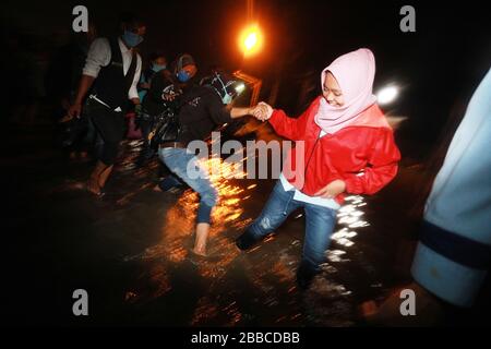 Bandung Regency, Indonesien. März 2020. Anwohner passieren die Straße bei einem Hochwasser in Bandung Regency, West Java, Indonesien, 30. März 2020. Überschwemmungen aufgrund der starken Regenintensität. (Foto von Agvi Firdaus/INA Photo Agency/Sipa USA) Credit: SIPA USA/Alamy Live News Stockfoto