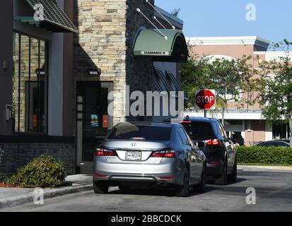 Coconut Creek, FL, USA. März 2020. Die Autos sind im Starbucks Drive-Thru verfügbar, da alle Geschäfte und Restaurants ihre Türen zum Essen in Innenräumen aufgrund der Pandemie von Coronavirus (COVID-19) am 30. März 2020 in Coconut Creek, Florida, geschlossen haben. Kredit: Mpi04/Media Punch/Alamy Live News Stockfoto