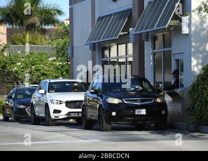 Coconut Creek, FL, USA. März 2020. Die Autos sind im Starbucks Drive-Thru verfügbar, da alle Geschäfte und Restaurants ihre Türen zum Essen in Innenräumen aufgrund der Pandemie von Coronavirus (COVID-19) am 30. März 2020 in Coconut Creek, Florida, geschlossen haben. Kredit: Mpi04/Media Punch/Alamy Live News Stockfoto