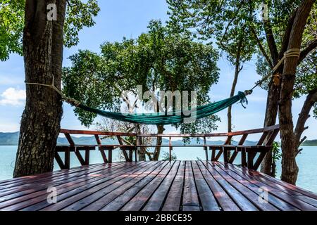 Hängematte zwischen Bäumen über Holzdeckeln mit Meerblick auf der Insel Ko Yao Noi, Phang-Nga Bay in der Nähe von Phuket, Thailand Stockfoto